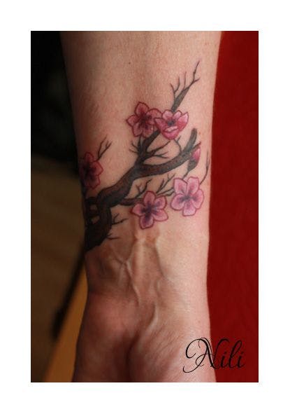 a blackwork tattoo design of a branch with pink flowers, reutlingen, germany