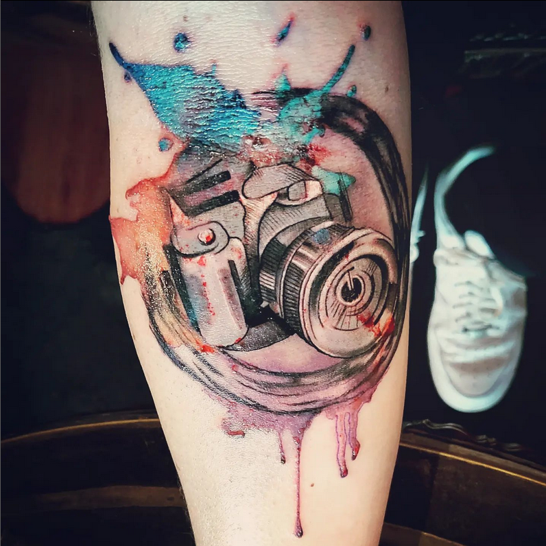 a cover-up tattoo with a camera and a paint sp on it, berlin, germany