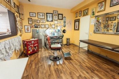 a room with a desk, chair and pictures on the wall