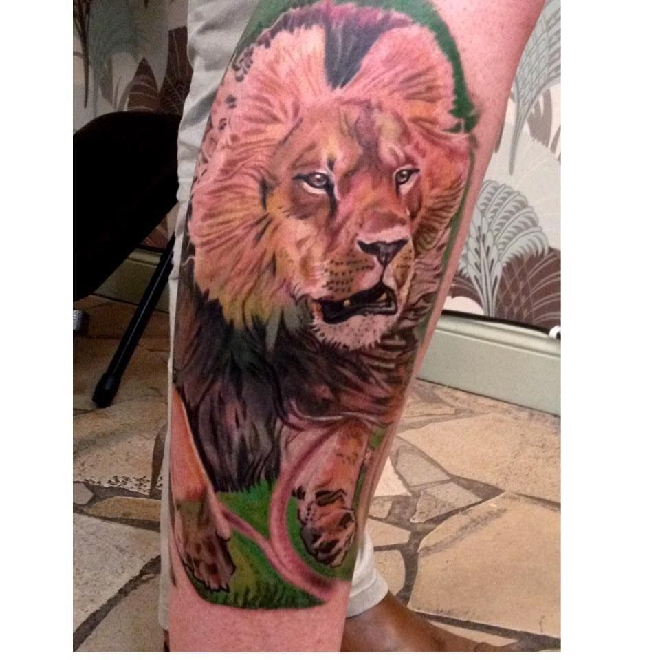 a cover-up tattoo of a lion with a green leaf, berlin, germany