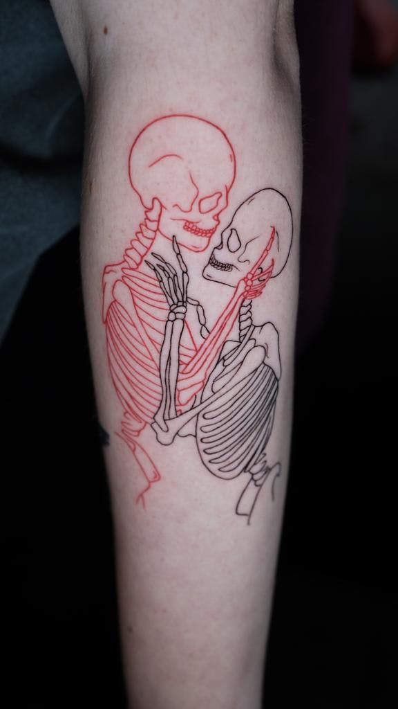 a skeleton and a skeleton hugging on the arm