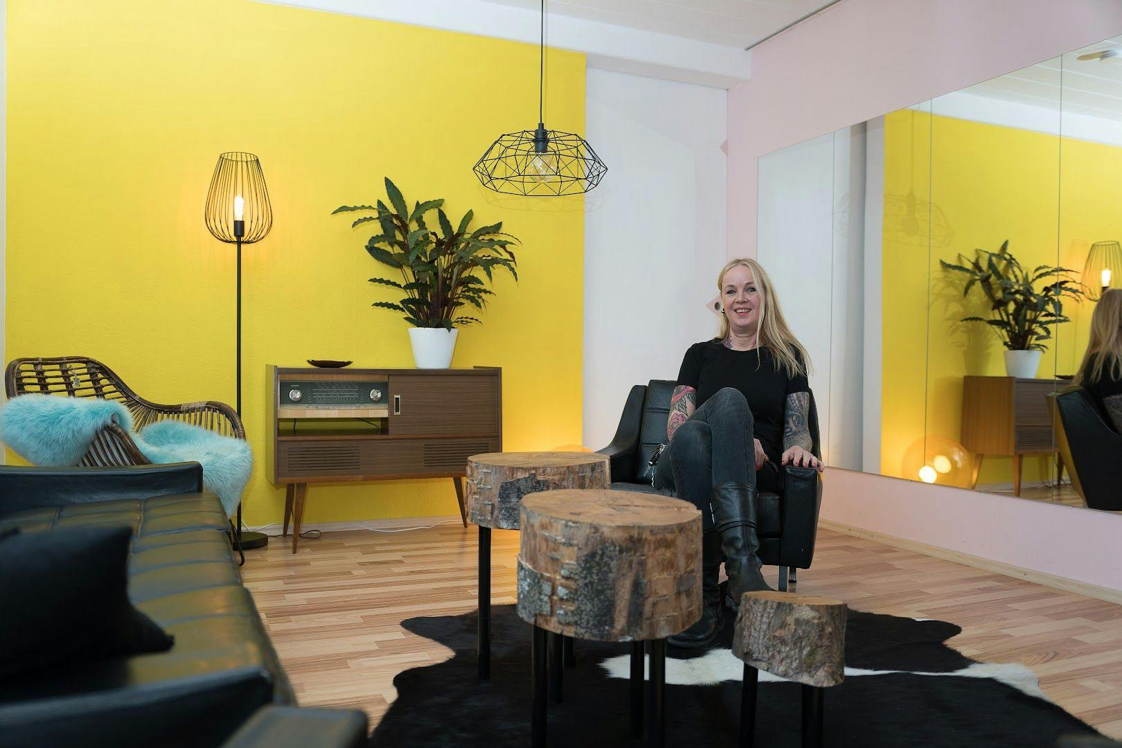 a woman standing in a room with a yellow wall