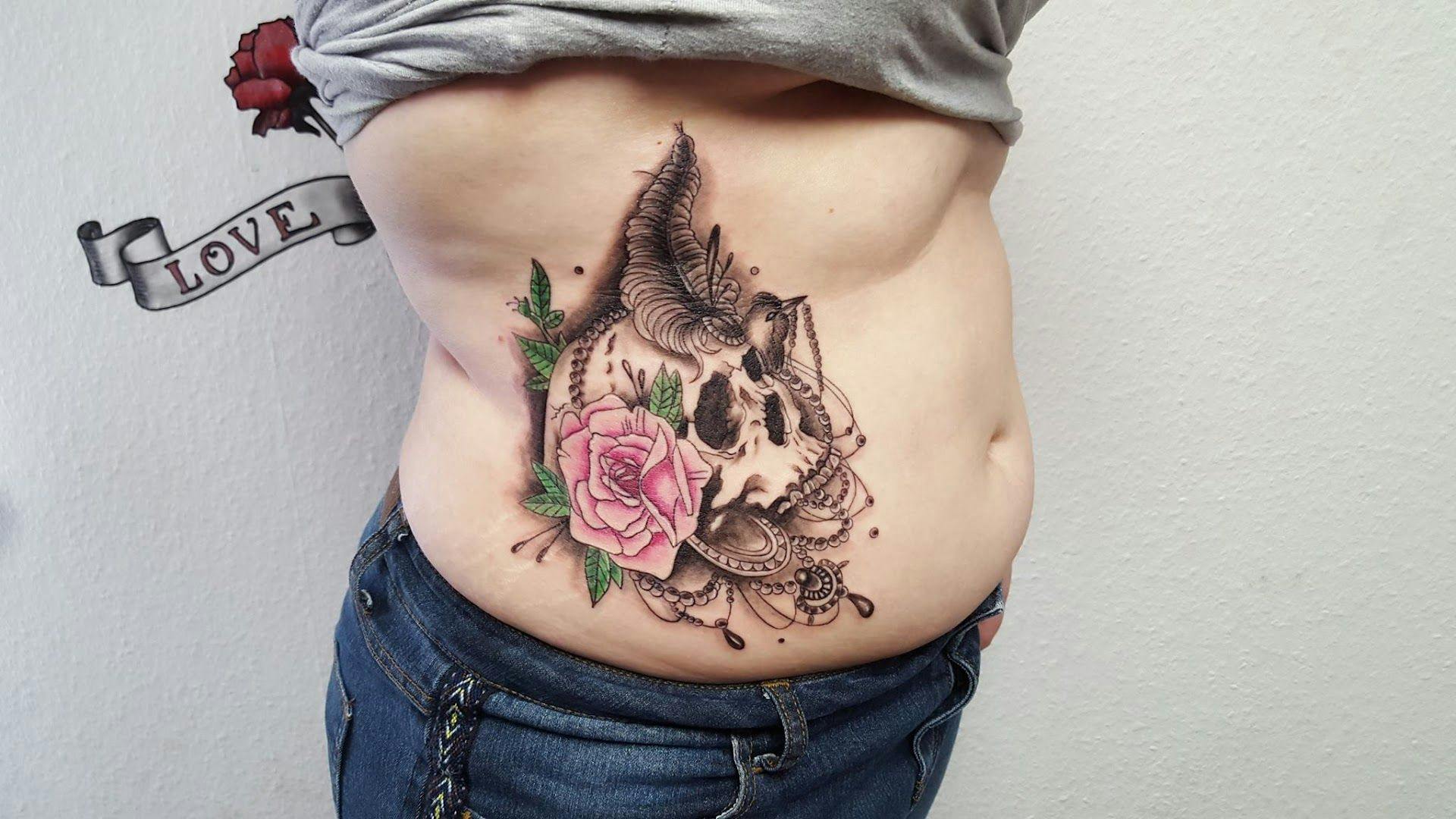 a woman's stomach with a rose and a bird japanische tattoos in leipzig, aschaffenburg, germany