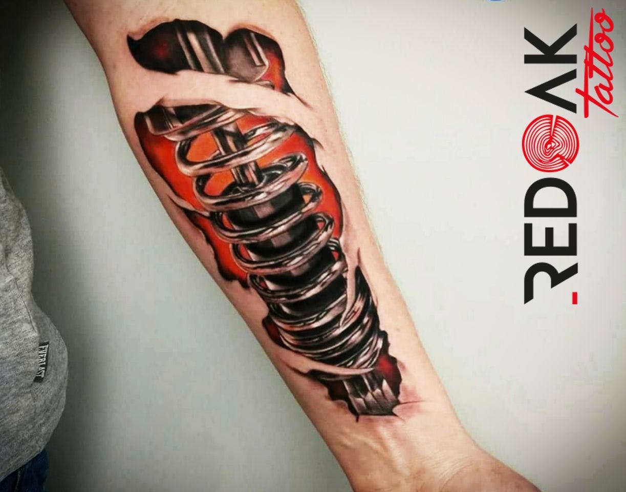 a cover-up tattoo of a red and black robot arm, viersen, germany