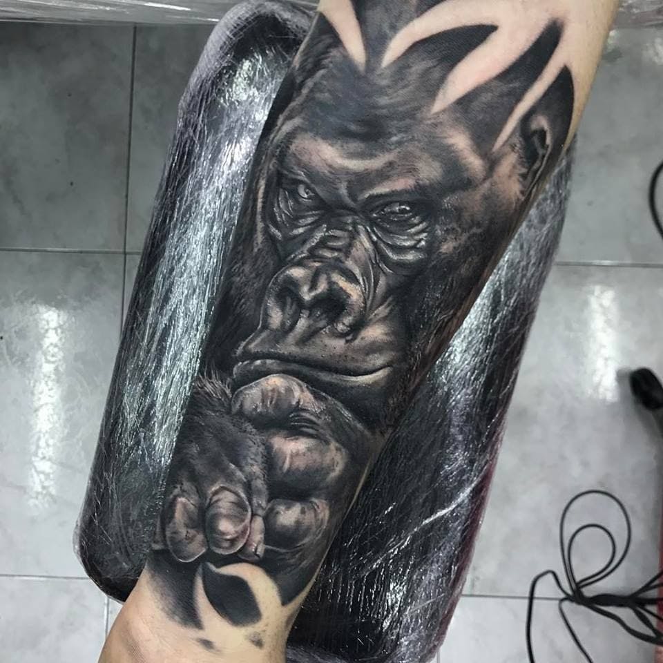 a cover-up tattoo of a gorilla with a skull on his arm, hamburg, germany