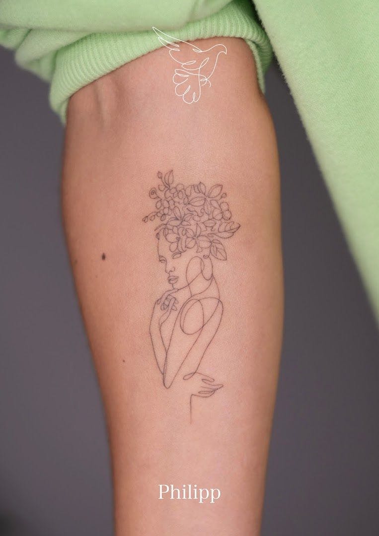 a woman's arm with a narben tattoo of a woman holding flowers, berlin, germany