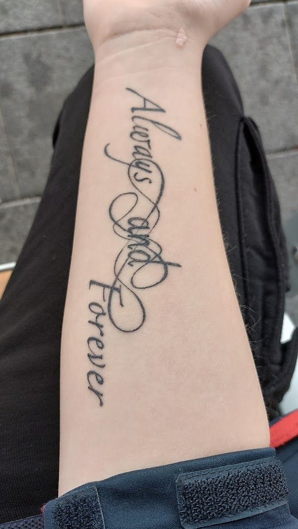 a woman's wrist cover-up tattoo with the word love written in curs, hamelin-pyrmont, germany