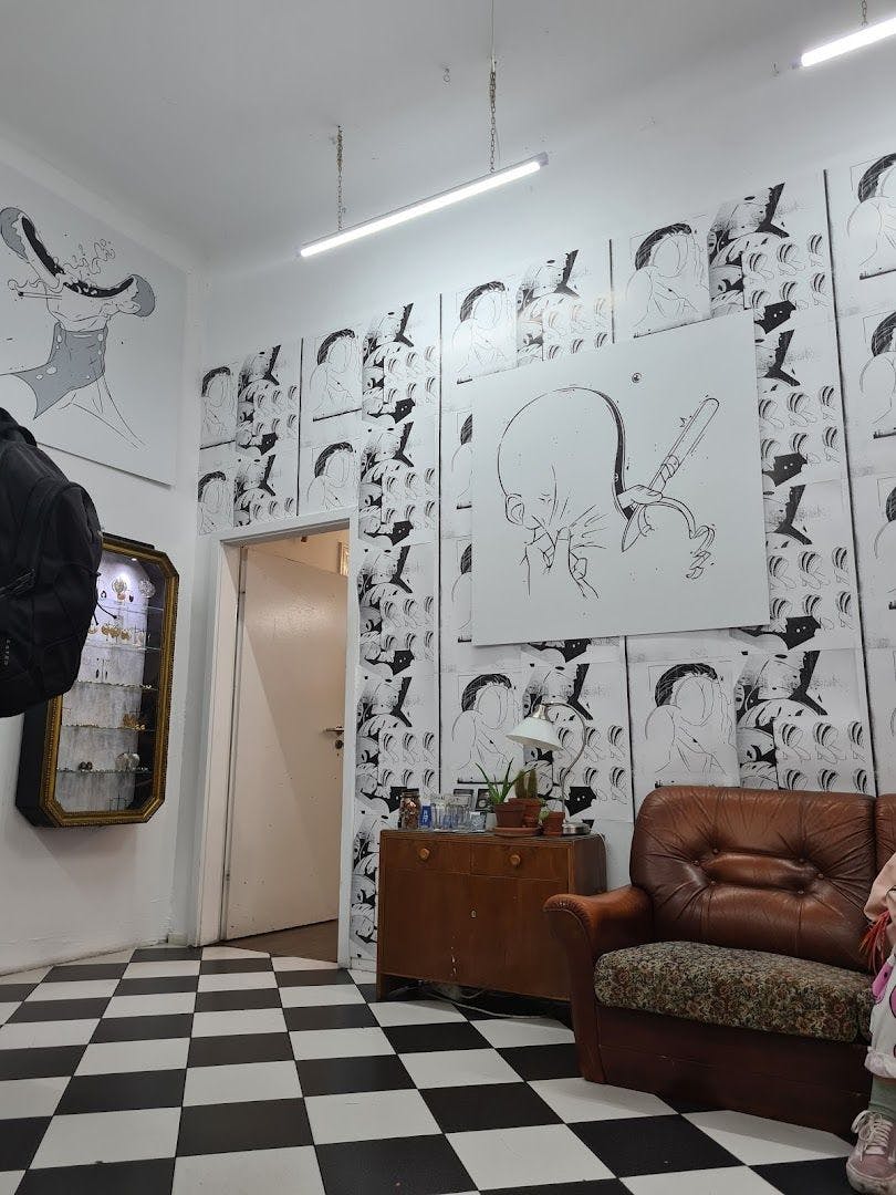 a room with a couch and a wall covered in black and white drawings