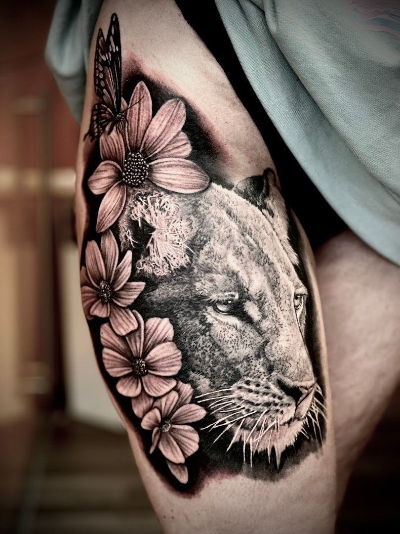 a black and white cover-up tattoo of a lion with flowers, erlangen-höchstadt, germany
