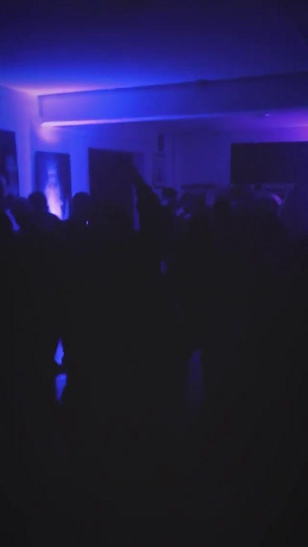 a crowd of people dancing in a dark room