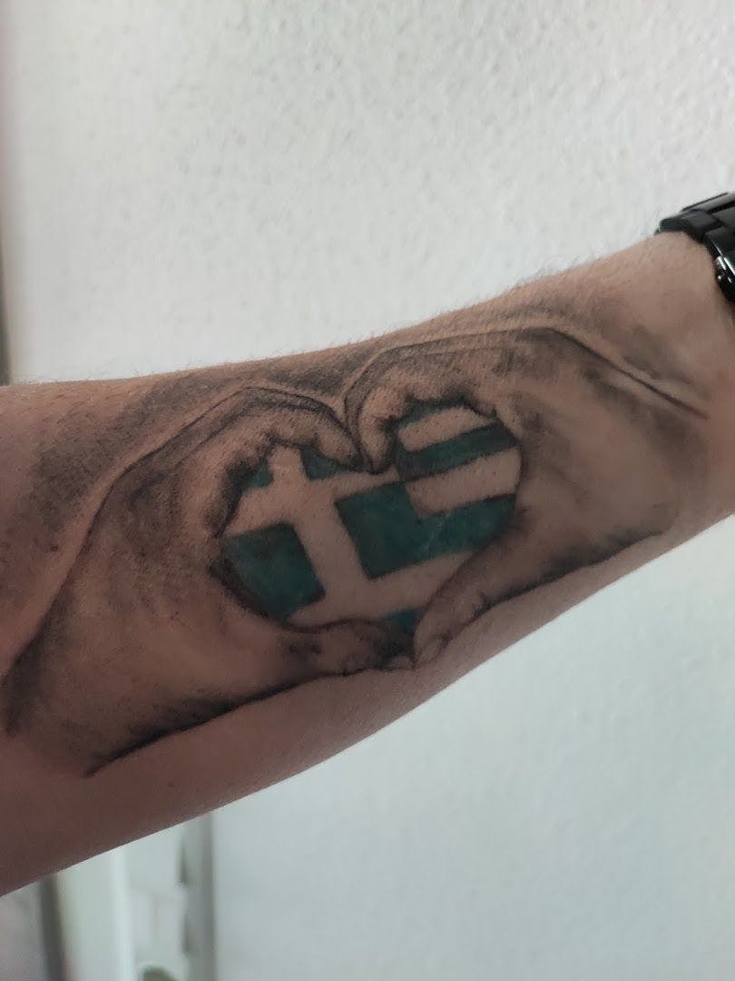 a man's hand with a green cross fineline tattoos on it, regen, germany