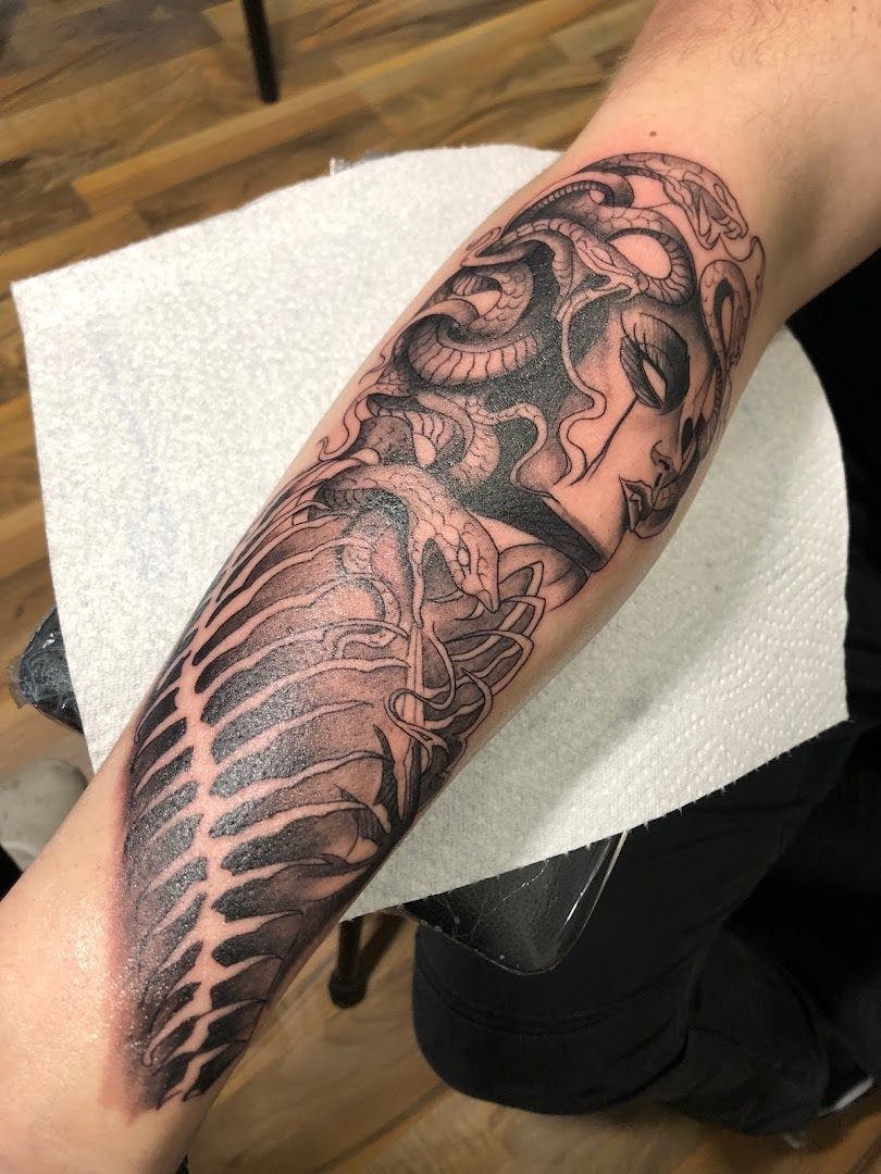 a black and white narben tattoo of a dragon on the arm, dillingen, germany