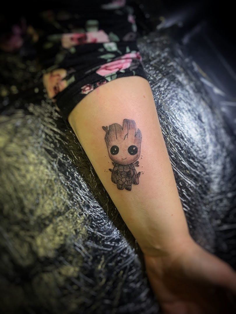 a small cover-up tattoo of a baby gro with a flower on the arm, oldenburg, germany